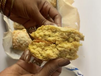 a tomato basil biscuit torn in half and held so the viewer can see the inside